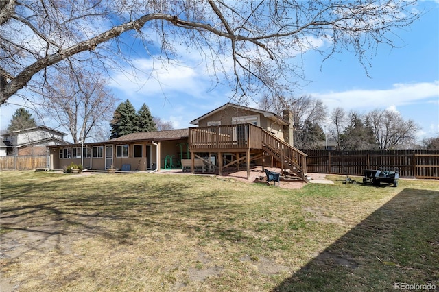 rear view of property with a chimney, a yard, and fence