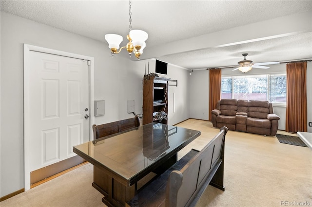 dining space with ceiling fan with notable chandelier, light colored carpet, and a textured ceiling