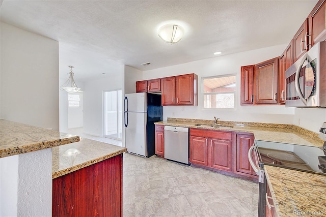 kitchen with a sink, light countertops, dark brown cabinets, and stainless steel appliances