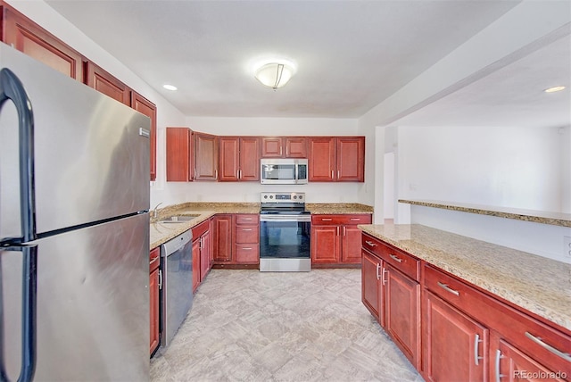 kitchen featuring light stone counters, recessed lighting, a sink, stainless steel appliances, and dark brown cabinets