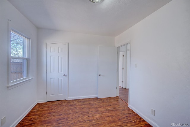 unfurnished bedroom featuring wood finished floors and baseboards