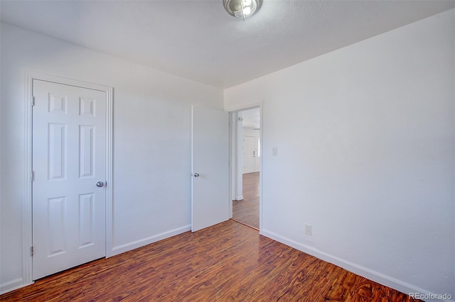 unfurnished bedroom featuring baseboards and wood finished floors