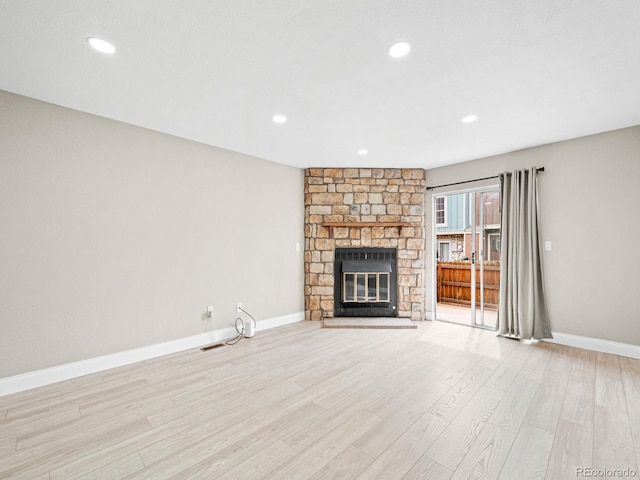unfurnished living room featuring a fireplace, light wood-style floors, baseboards, and recessed lighting