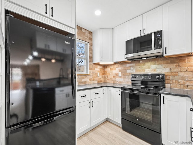kitchen featuring black appliances, decorative backsplash, white cabinets, dark countertops, and light wood-style flooring