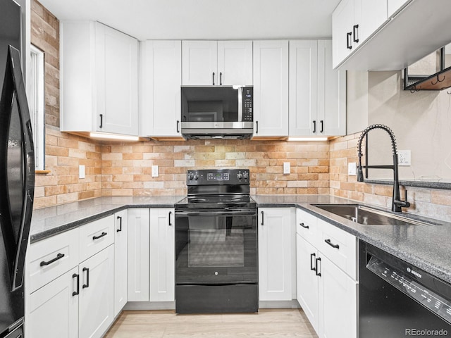 kitchen featuring black appliances, a sink, and white cabinets