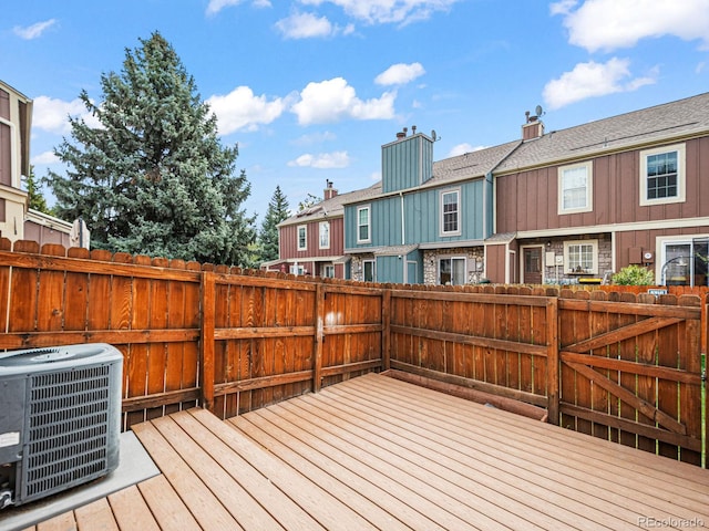 deck with cooling unit, a fenced backyard, and a residential view