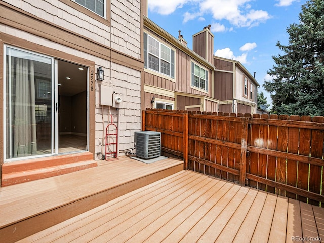 wooden deck with central AC unit and fence