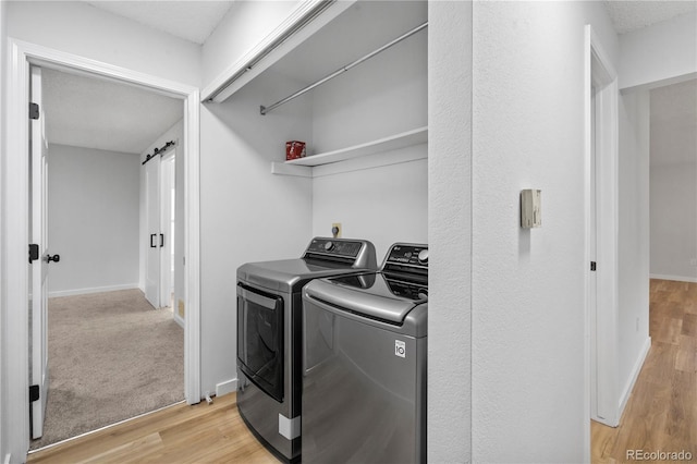 2090 S Fairplay St, Aurora, CO 80014 - washroom with separate washer and dryer, light wood-style floors, and baseboards