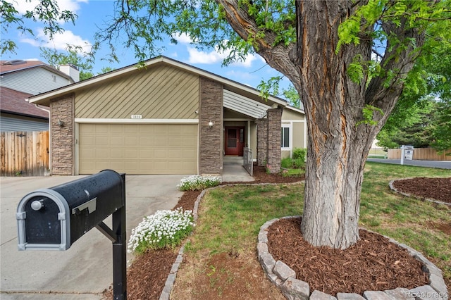 2090 S Fairplay St, Aurora, CO 80014 - mid-century home with concrete driveway, a garage, and stone siding