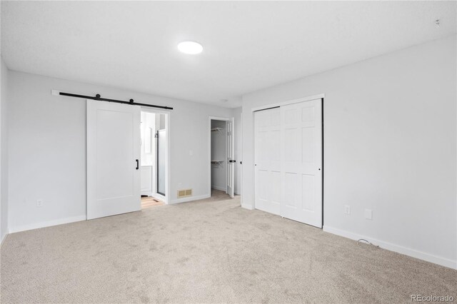 2090 S Fairplay St, Aurora, CO 80014 - unfurnished bedroom featuring carpet, baseboards, a barn door, and ensuite bathroom