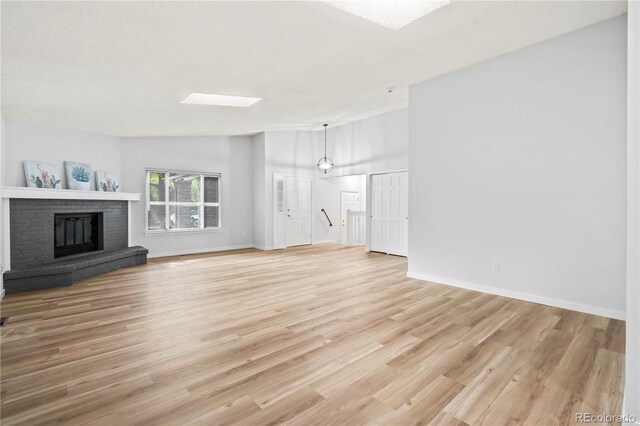 2090 S Fairplay St, Aurora, CO 80014 - unfurnished living room with light wood-style floors, a fireplace, and baseboards