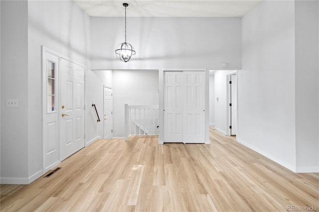 2090 S Fairplay St, Aurora, CO 80014 - unfurnished dining area with a high ceiling, light wood-style floors, and baseboards