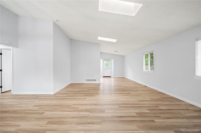 2090 S Fairplay St, Aurora, CO 80014 - spare room featuring a skylight, lofted ceiling, light wood finished floors, healthy amount of natural light, and baseboards