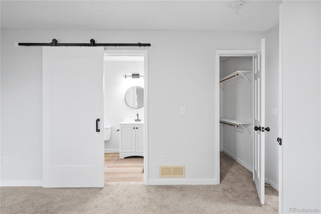 2090 S Fairplay St, Aurora, CO 80014 - unfurnished bedroom featuring carpet flooring, a spacious closet, a closet, a barn door, and baseboards