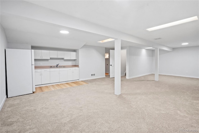 2090 S Fairplay St, Aurora, CO 80014 - finished basement featuring light carpet, freestanding refrigerator, a sink, baseboards, and recessed lighting
