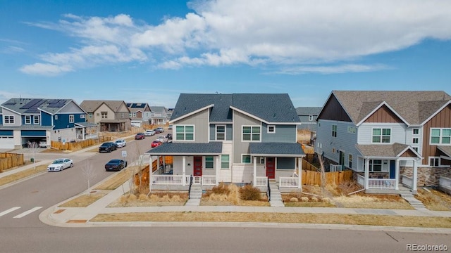 21821 E 7th Ave, Aurora, CO 80018 - view of property featuring roof with shingles, a residential view, covered porch, and fence