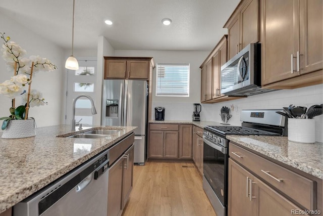 21821 E 7th Ave, Aurora, CO 80018 - kitchen with appliances with stainless steel finishes, light wood-style flooring, light stone countertops, and a sink