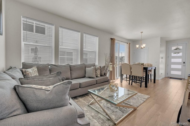 21821 E 7th Ave, Aurora, CO 80018 - living room featuring light wood-style flooring and a notable chandelier