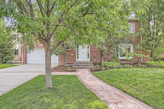 obstructed view of property with concrete driveway, brick siding, and a front yard