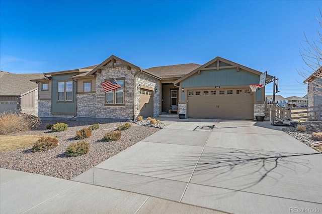 view of front facade featuring a garage, stone siding, and driveway