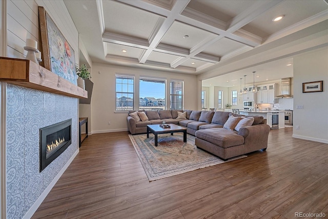 living area featuring beam ceiling, dark wood-style flooring, and a wealth of natural light