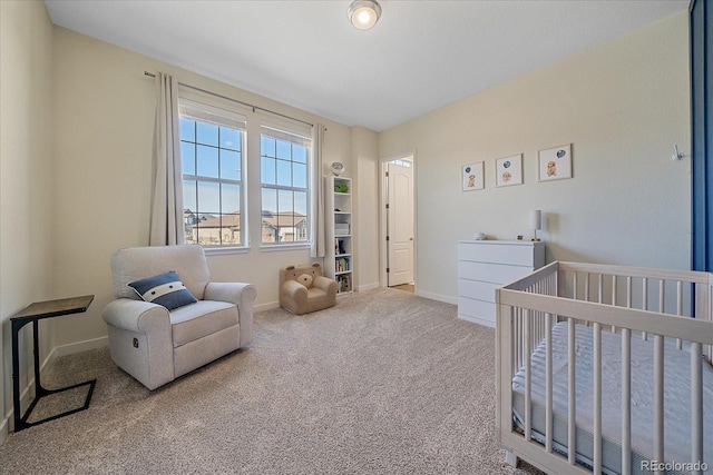 carpeted bedroom featuring baseboards and a nursery area