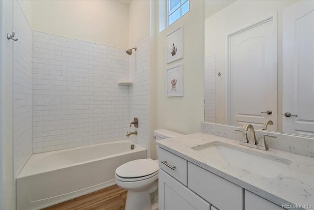 full bath with bathtub / shower combination, toilet, wood finished floors, and vanity