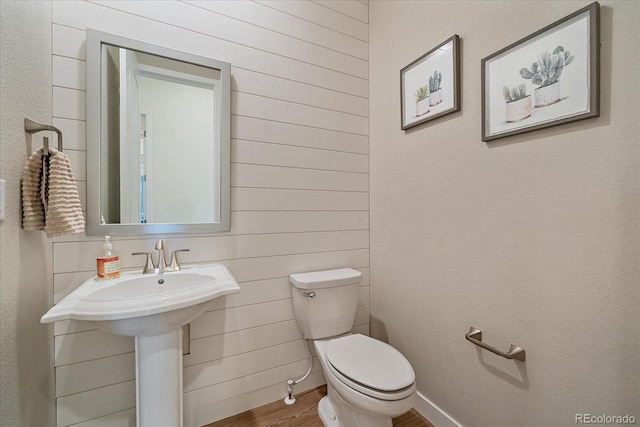 half bathroom featuring toilet and wood finished floors