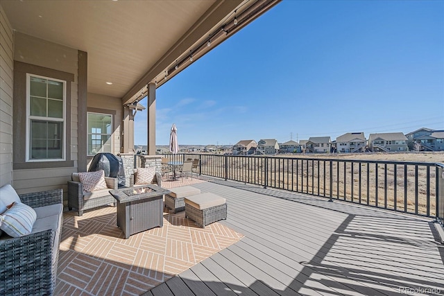 deck with a residential view and an outdoor living space with a fire pit