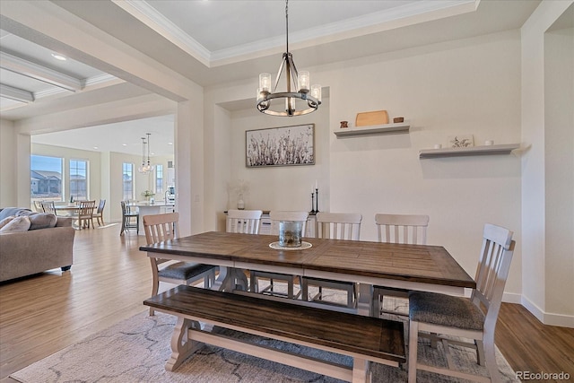 dining space featuring crown molding, wood finished floors, baseboards, and a chandelier