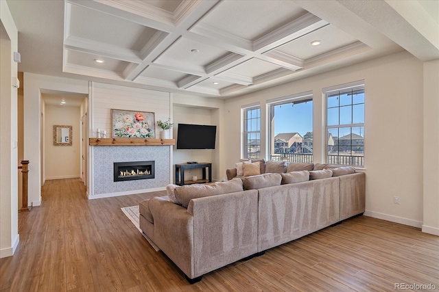 living room with a glass covered fireplace, beamed ceiling, wood finished floors, and baseboards