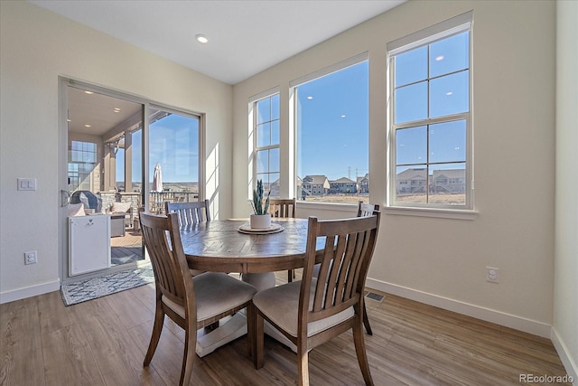 dining space featuring light wood finished floors, visible vents, recessed lighting, and baseboards