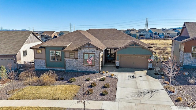 view of front facade featuring an attached garage, stone siding, and driveway