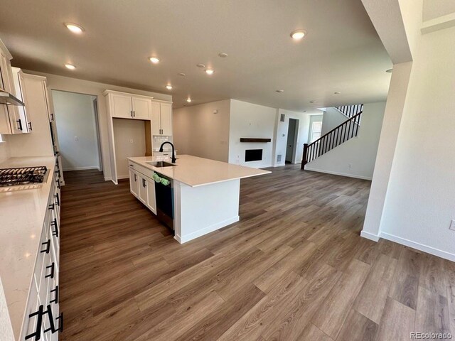 245 Wooten Ave, Brighton, CO 80601 - kitchen featuring dishwasher, white cabinets, stainless steel gas cooktop, dark wood-type flooring, and light countertops