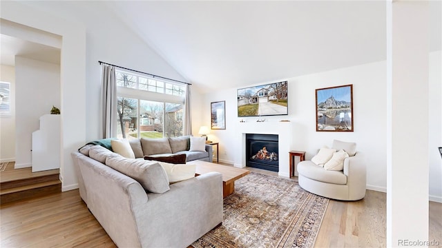 living room with light wood-type flooring and high vaulted ceiling