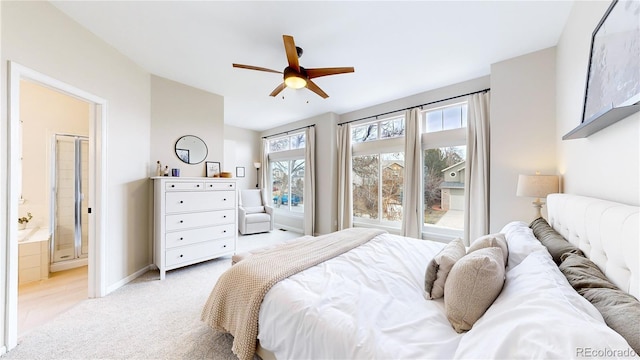 bedroom featuring ceiling fan, light colored carpet, and ensuite bathroom