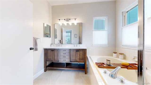 bathroom featuring tile patterned floors, vanity, and a relaxing tiled tub