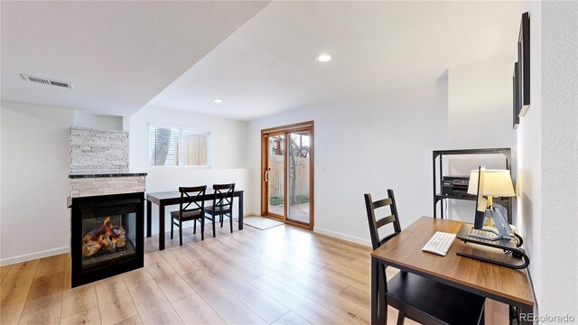 interior space with a stone fireplace and light hardwood / wood-style flooring