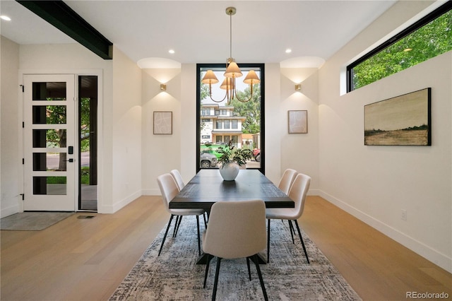 dining area featuring beamed ceiling and wood-type flooring