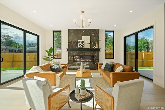 living room featuring a fireplace, light hardwood / wood-style floors, and a chandelier