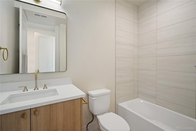 full bathroom with tiled shower / bath, vanity, and toilet