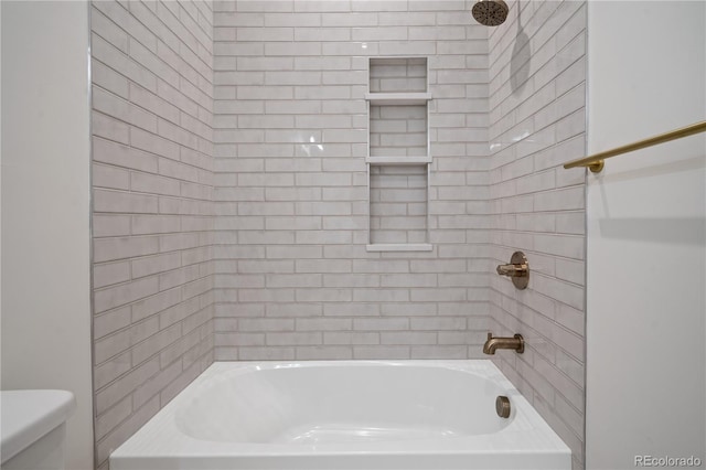 bathroom with toilet and tiled shower / bath