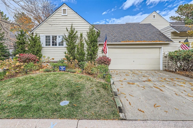 view of front of property featuring a garage and a front lawn