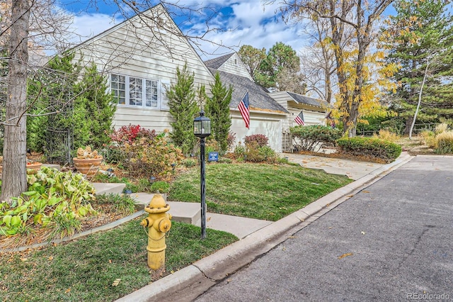 bungalow featuring a garage and a front lawn