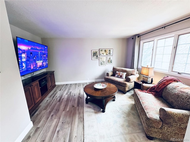 4505 S Yosemite St Unit 102, Denver, CO 80237 - living area featuring a textured ceiling, baseboards, and wood finished floors