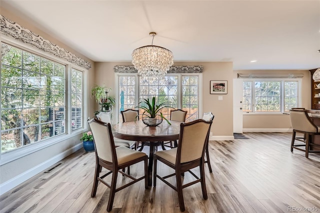 4505 S Yosemite St Unit 102, Denver, CO 80237 - dining space featuring baseboards, a notable chandelier, visible vents, and light wood-style floors