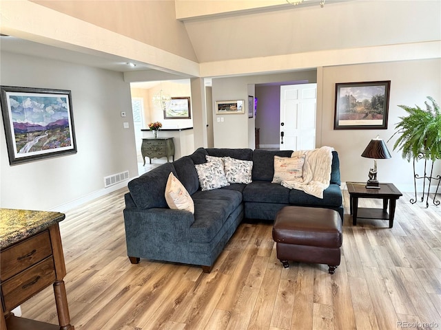 4505 S Yosemite St Unit 102, Denver, CO 80237 - living area featuring baseboards, light wood-style floors, visible vents, and vaulted ceiling
