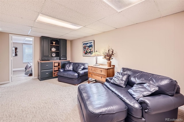 4505 S Yosemite St Unit 102, Denver, CO 80237 - living area featuring a paneled ceiling, light carpet, and baseboards