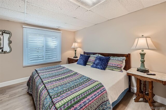 4505 S Yosemite St Unit 102, Denver, CO 80237 - bedroom with baseboards, a paneled ceiling, and wood finished floors