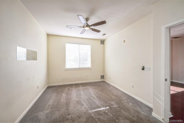 spare room with dark carpet and ceiling fan